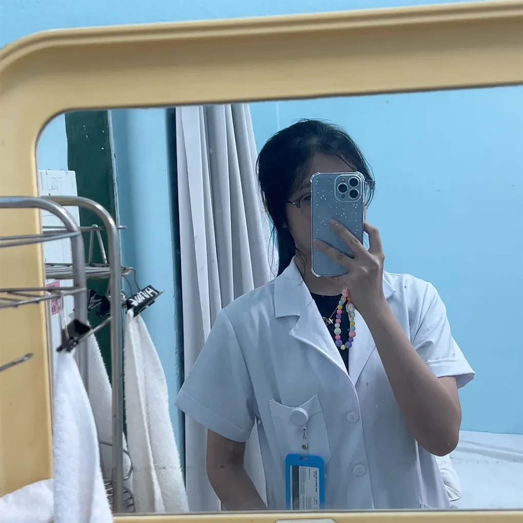 Phương Vy chụp ảnh qua gương trong trang phục thực tập màu trắng