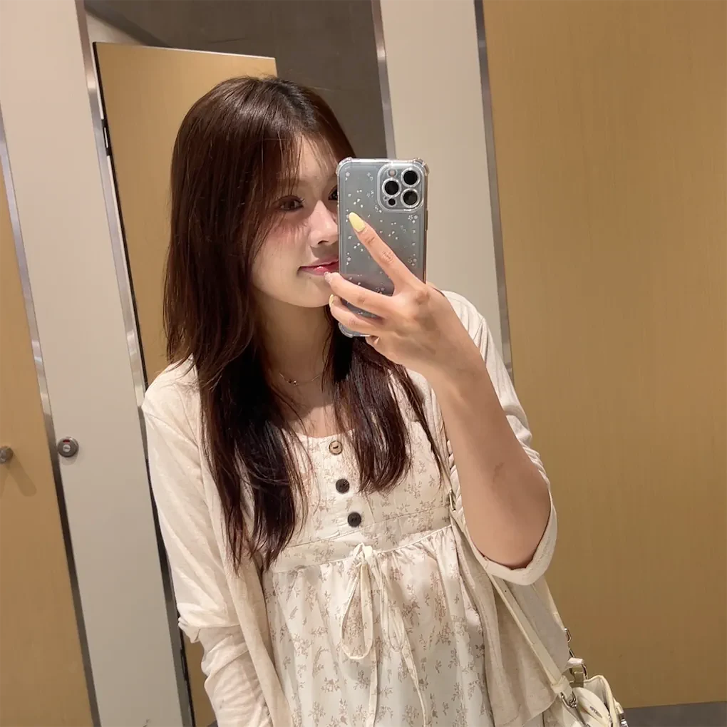 Phương Vy chụp ảnh qua gương trong trang phục hoa màu sáng