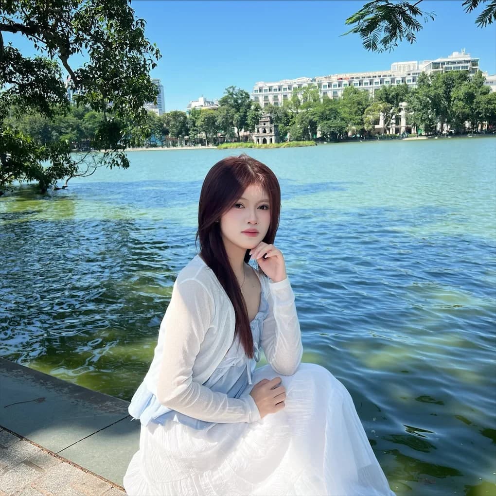 Phương Vy ngồi bên hồ trong ngày nắng xanh